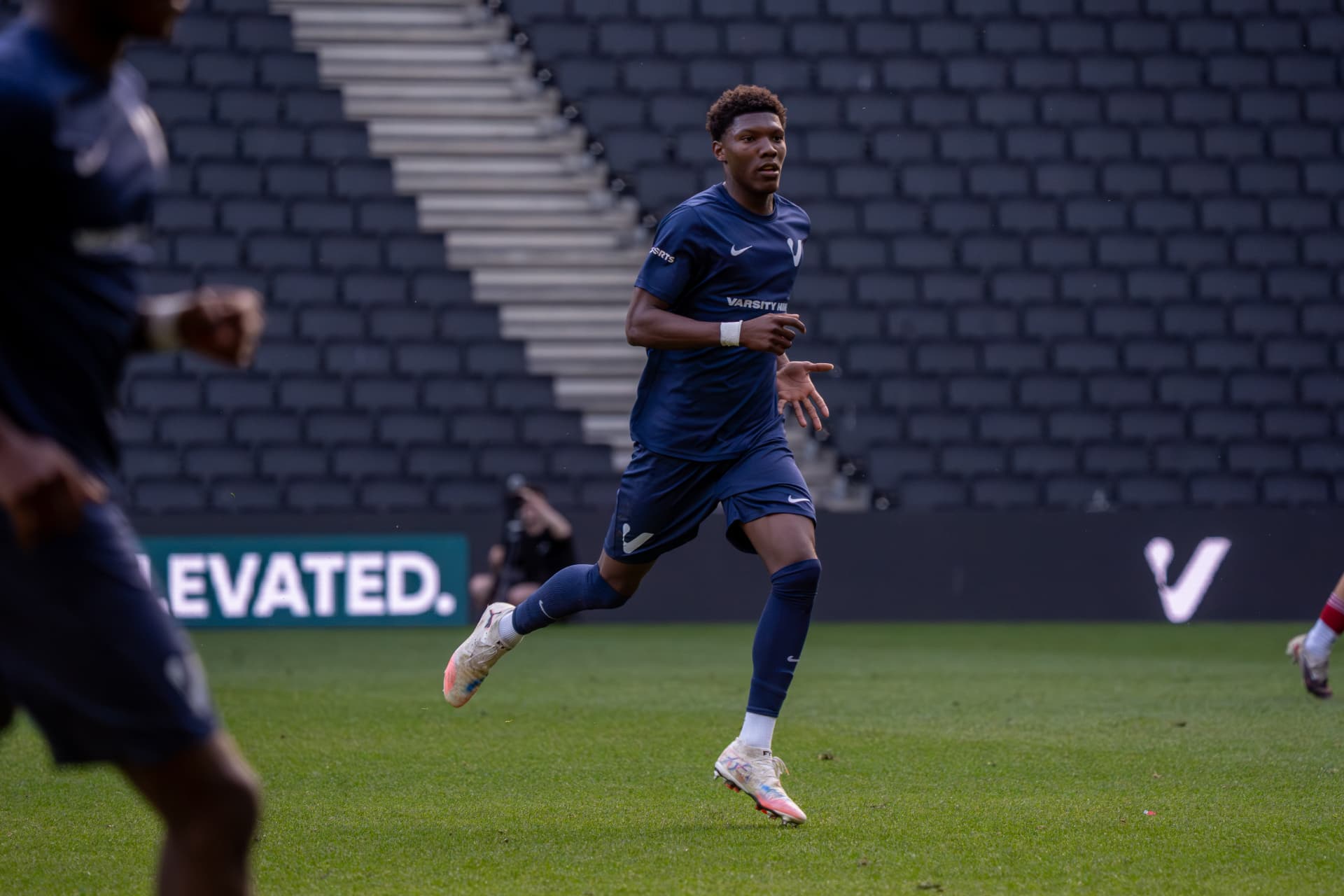 Player in navy sprinting into the attacking half
